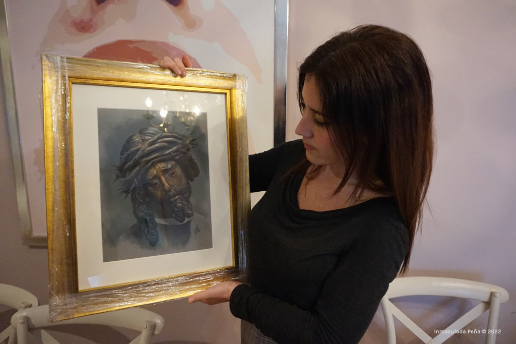 La artista Inmaculada Peña con el retrato a Pastel de Nuestro Padre Jesús del Gran Poder.